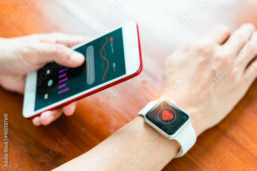 Close-up of a smart watch health tracker with the heart rate shown on the watch and smartphone screens. Modern stylish and innovation wearable device photo