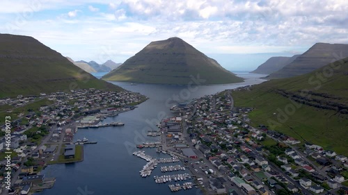 Beautiful Cinematic aerial footage of the City of Klaksvik in the Fareo Islands with its colorful houses and amazing canal and view of the majestic Kunoy Park