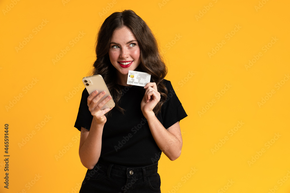 White young woman posing with credit card and mobile phone White young woman posing with credit card and mobile phone