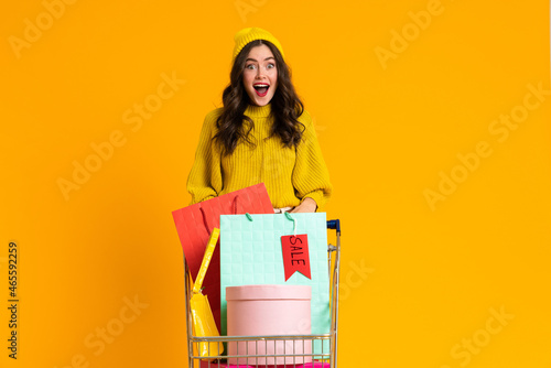 Excited woman screaming while posing with shopping cart