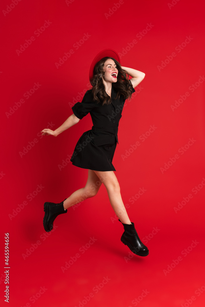White woman wearing dress laughing while dancing on camera