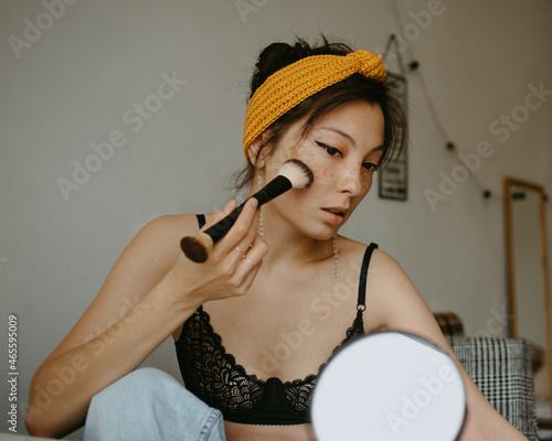 attractive woman doing makeup at home 