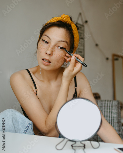 attractive woman doing makeup at home 