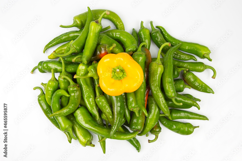 green hot peppers and yellow bell peppers on a white background. vitamin vegetables for health