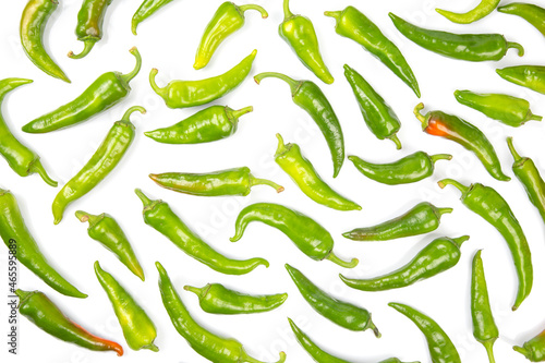 green hot peppers evenly spread on a white background. vitamin vegetables for health