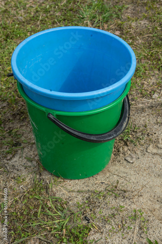 two plastic buckets are on the ground