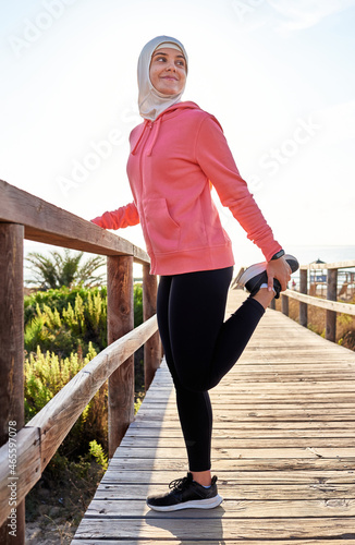 Young muslim woman stretching after sport photo