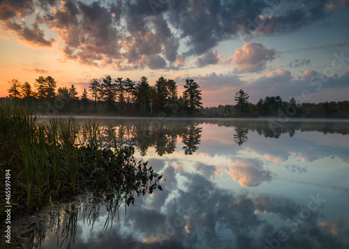 Fototapeta Naklejka Na Ścianę i Meble -  A sunrise sky reflected in the calm surface of a secluded Northwoods lake.  Oneida County, Wisconsin.
