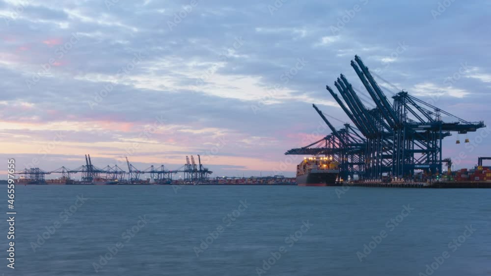 Felixstowe, United Kingdom - October 24 2021: Sunset timelapse as container cargo is loaded on-board ships at the Port of Felixstowe, amid a major worldwide supply chain crisis Felixstowe, United Kingdom - October 24 2021: Sunset timelapse as container cargo is loaded on-board ships at the Port of Felixstowe, amid a major worldwide supply chain crisis