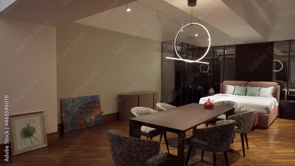Wide shot bedroom with bed table and paintings on parquet floor indoors. Luxurious expensive furniture and decorations for sale in furnishing store showroom Wide shot bedroom with bed table and paintings on parquet floor indoors. Luxurious expensive furniture and decorations for sale in furnishing store showroom