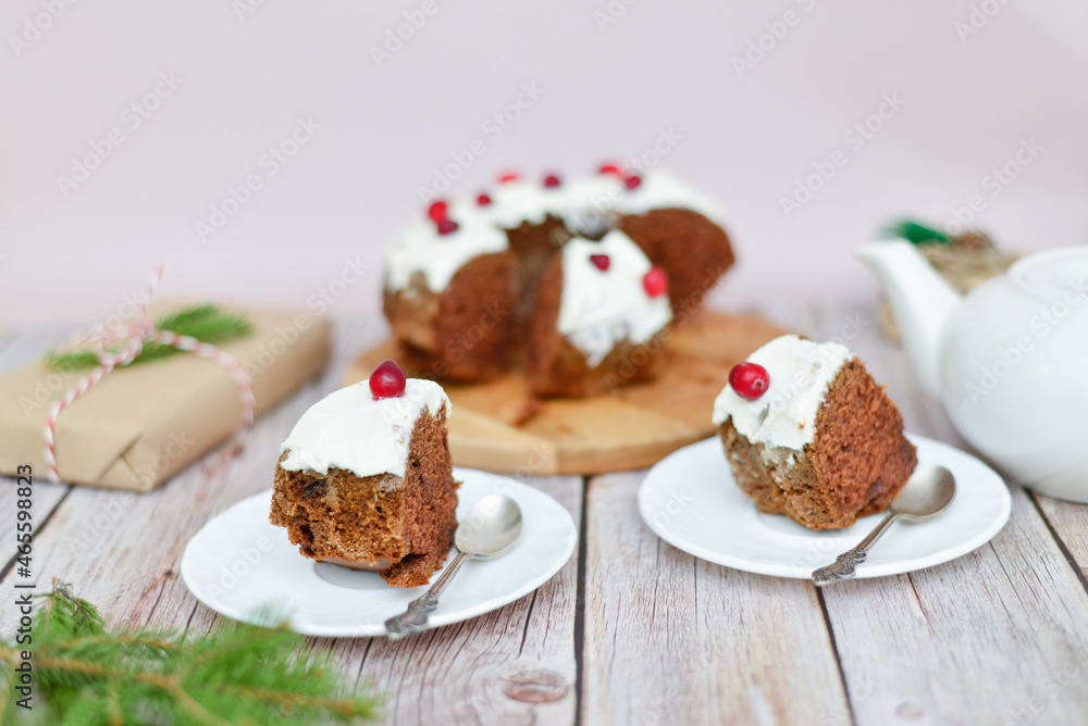 A Christmas cake and two pieces on the wooden background. Horizontal frame.