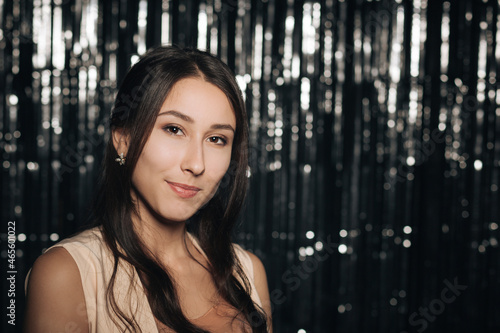 A young woman at a party, on a silver shiny background