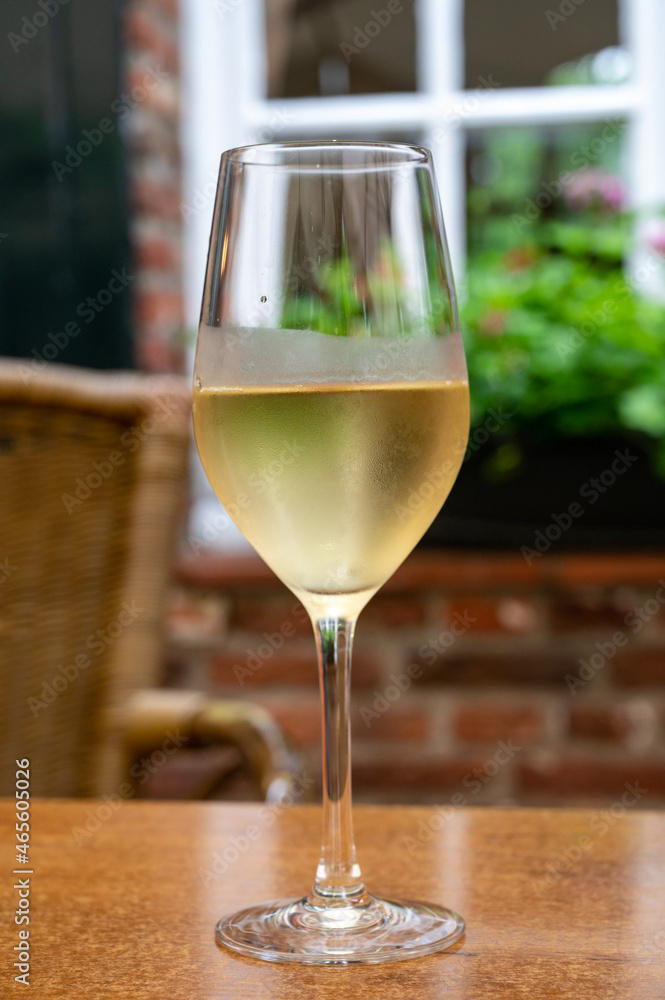 Glass of cold white wine served on outdoor terrace in old French cafe Glass of cold white wine served on outdoor terrace in old French cafe