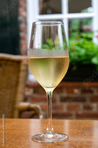Glass of cold white wine served on outdoor terrace in old French cafe