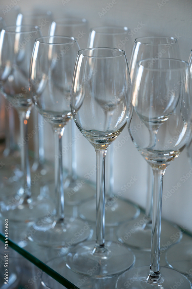 Many empty clean wine glasses on shelf in restaurant Many empty clean wine glasses on shelf in restaurant