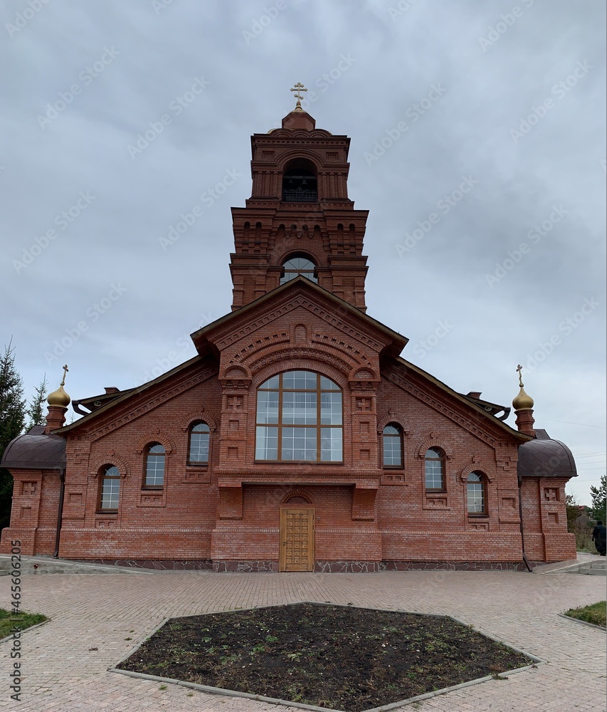 Orthodox church made of red bricks with golden baths and a cross