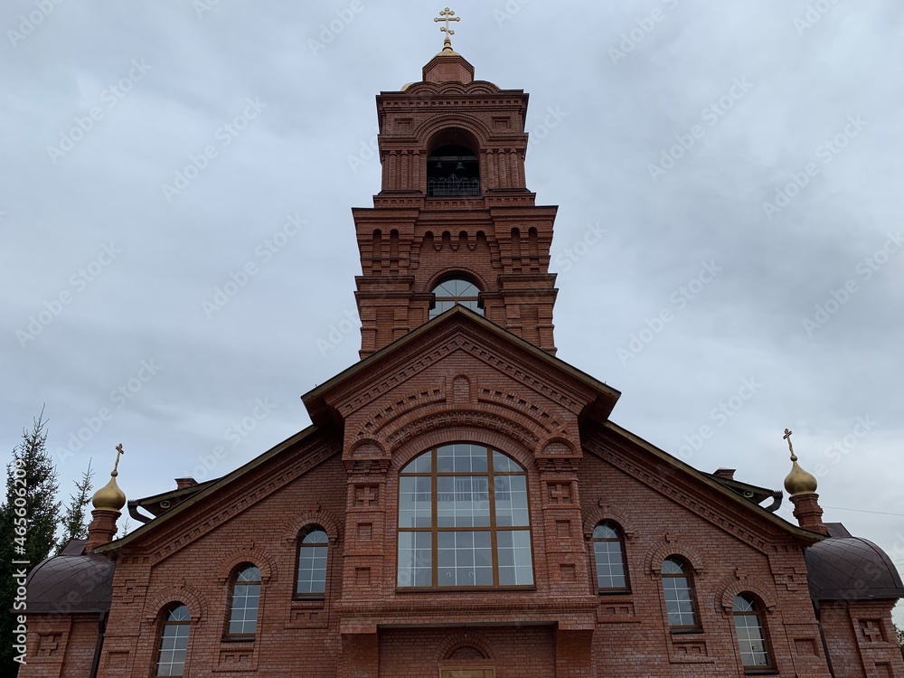Obraz premium Orthodox church made of red bricks with golden baths and a cross