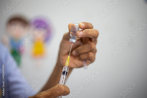 Close-up of doctors  nurses  sucking vaccines from bottles  preparing to vaccinate against and cure from coronavirus  covid-19  flu  infection. Medical concept of vaccination.