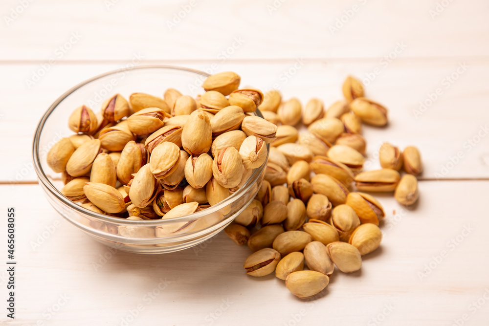Pistachio nuts in a shell with salt on a background of white boards. Beer appetizer - salted nuts. concept is snacks for beer. Pistachio nuts in a shell with salt on a background of white boards. Beer appetizer - salted nuts. concept is snacks for beer.