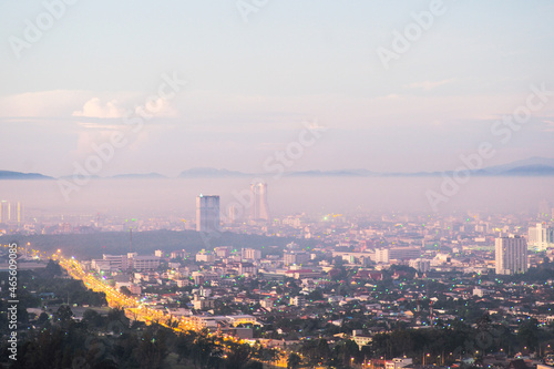 Aerial view of citscape from the top of mountain covered by the fog with horizontal line of mountain in background with sunrise in the morning photo