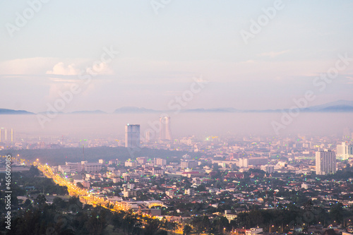 Aerial view of citscape from the top of mountain covered by the fog with horizontal line of mountain in background with sunrise in the morning