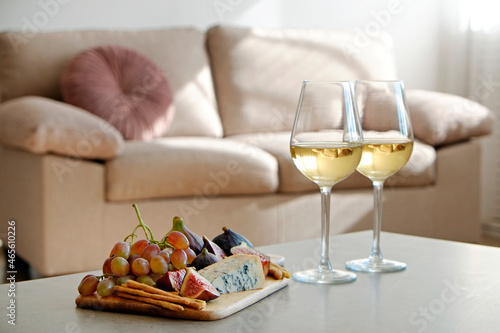 Foto Two wineglasses of vintage chardonnay with delicious appetizers