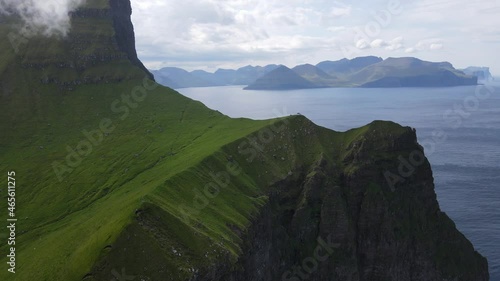 Beautiful aerial footages of the Kallur Light house in the Faroe Islands, and its massive cliffs, crags hikes and ocean views photo