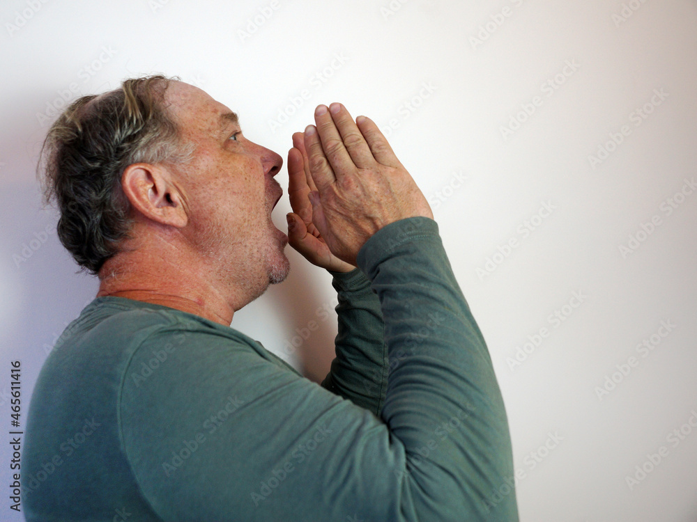 a man shouts into his hands in the form of a megaphone a man shouts into his hands in the form of a megaphone