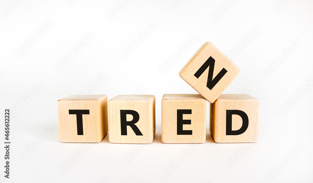 Trend symbol. The concept word 'trend' on wooden cubes on a beautiful white table, white background. Business and trend concept. Copy space. Trend symbol. The concept word 'trend' on wooden cubes on a beautiful white table, white background. Business and trend concept. Copy space.