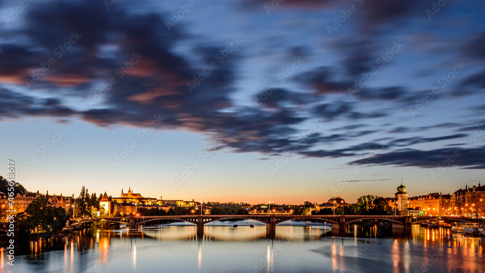 Cityscape of Jiraskuv bridge with the Prague castle in the background in twilight. 