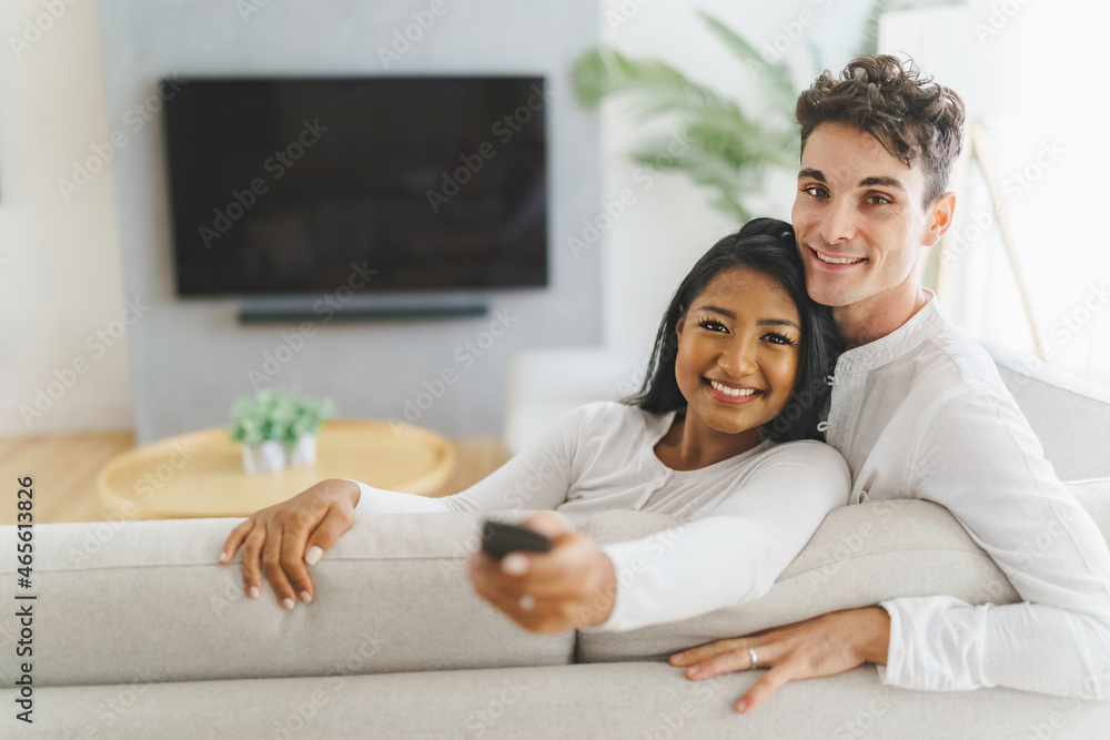 Obraz premium Couple watching tv in their living room at home
