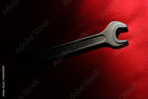 The horn wrench is partially illuminated on a red fabric background