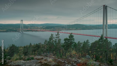 Time lapse of Högakustenbron bridge in West Sweden in the area Hoega Kusten, moving clouds in sky, trees in front
 photo