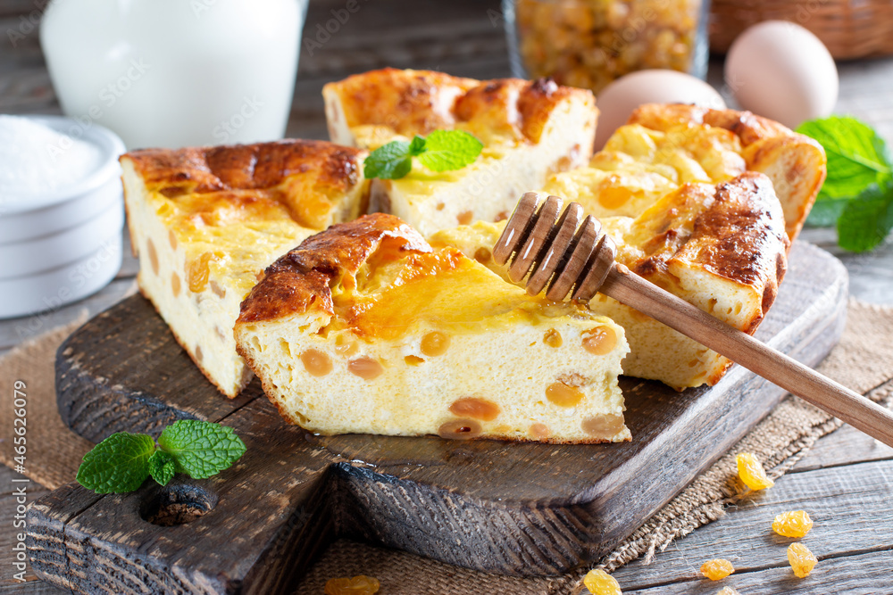Cottage cheese casserole with raisins on wooden background