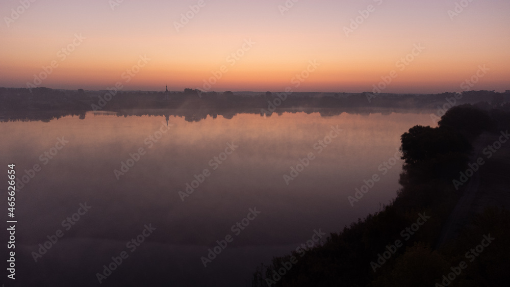 Obraz premium Beautiful foggy morning. Fog over autumn lake at sunrise moment. Wide panorama.