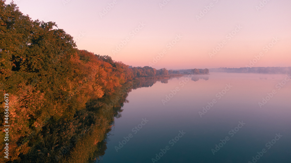 Obraz premium Beautiful foggy morning. Fog over autumn lake at sunrise moment. Wide panorama.