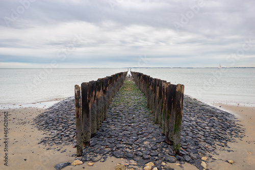 Scenic view of a pier with wooden posts at the North Sea coast.