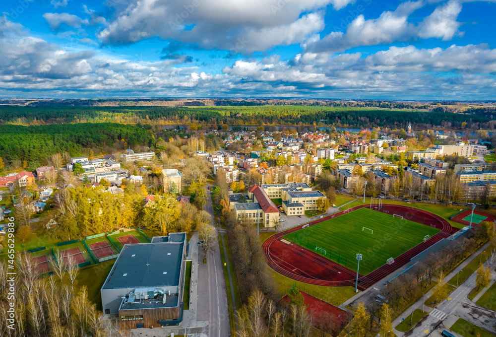 Obraz premium Aerial panoramic view of Birstonas resort city in Lithuania. Stadium and city houses during a sunny day