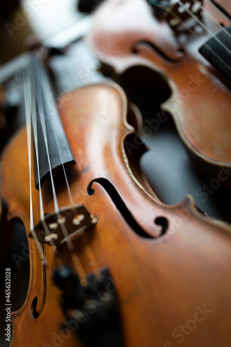 A shallow depth of field shot of a violin or a viola which is a string instrument that is common to a classical orchestra