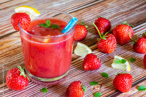 Glass of fresh strawberry smoothie on wooden background