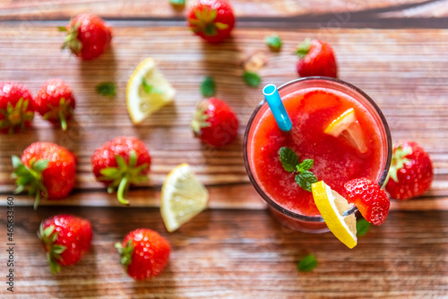 Glass of fresh strawberry smoothie on wooden background