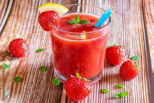 Glass of fresh strawberry smoothie on wooden background