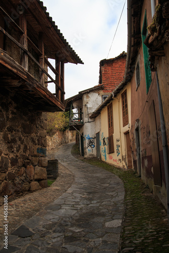 Vertical shot of an old street with old houses with graffitis photo