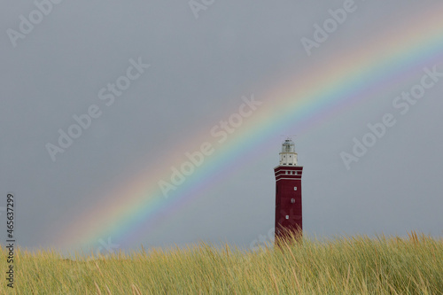 Westhoofd lighthouse in Ouddorp with beach grass  and rainbow photo