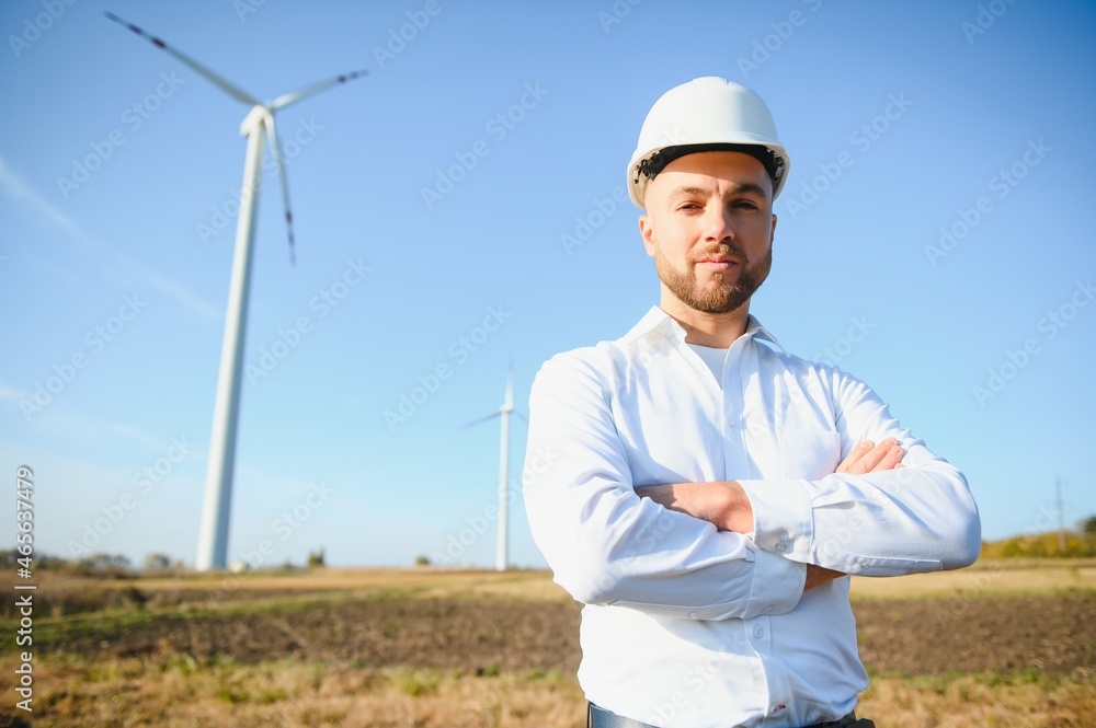Engineer in wheat field checking on turbine production Engineer in wheat field checking on turbine production