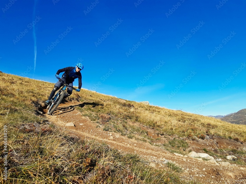 Enduro ride with steep bend, banked curve, Swiss Mountain Alps at Davos Switzerland. With blue clear sky and great view