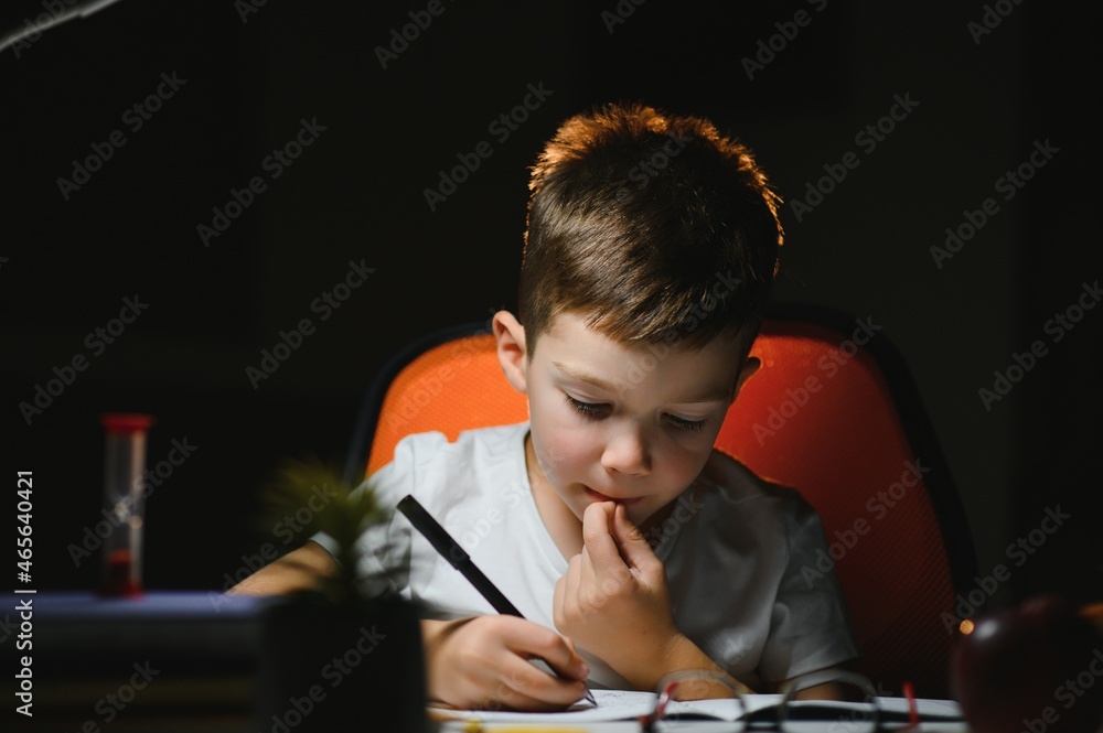 boy doing homework at home in evening boy doing homework at home in evening