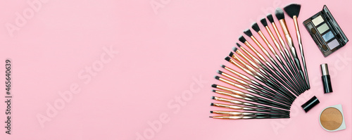 Various Makeup brushes full set  lipstick  eyeshadow and powder  everyday make up professional tools  decorative beauty cosmetics accessories on pastel pink background copy space. Top View banner