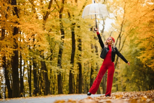 girl with a umbrella  flying on an umbrella  jumping and having fun in a yellow autumn landscape