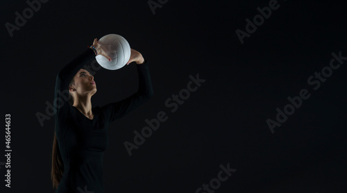 Volleyball girl serve ball on dark background. Player doing sport workout online.Horizontal sport poster, greeting cards, headers, website and app